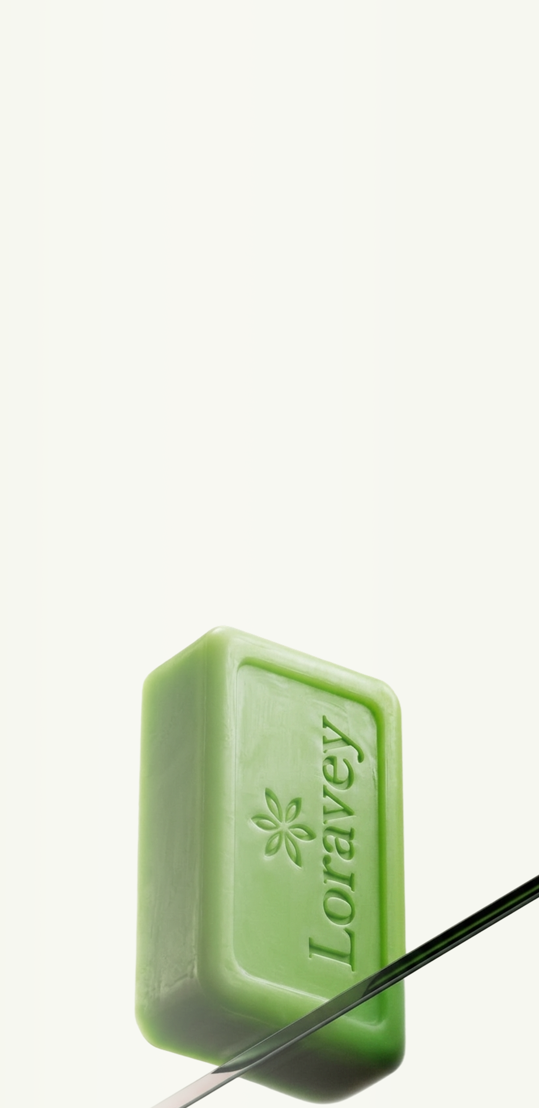 A green Loravey-embossed soap bar on a cream background